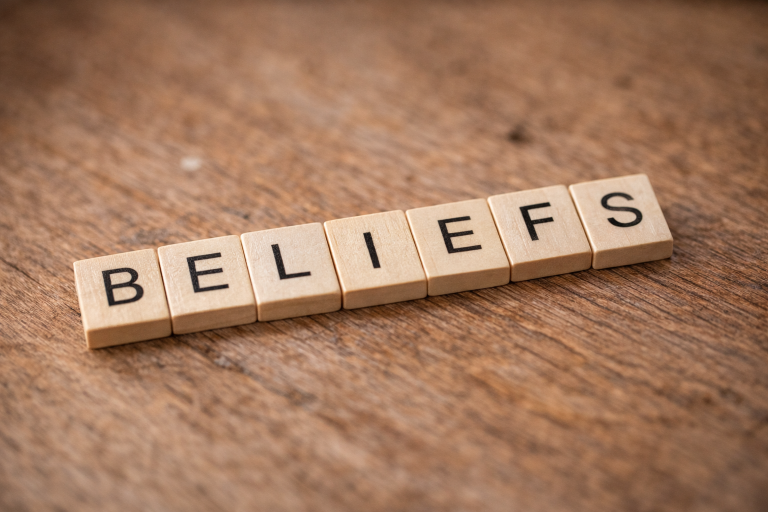 Holzbuchstaben mit dem Wort BELIEFS auf einem Holztisch